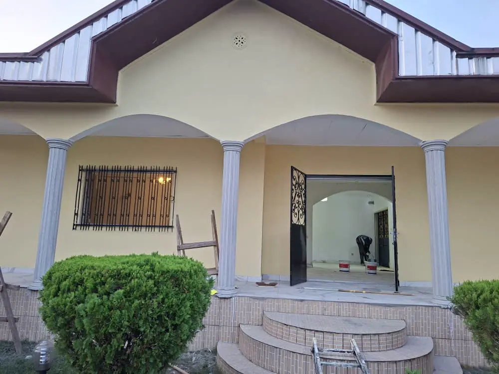 Villa en cours de rénovation, façade peinte et équipe sur le perron — vue 4