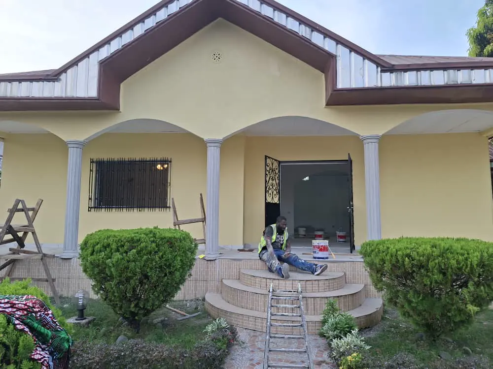 Villa en cours de rénovation, façade peinte et équipe sur le perron — vue 3