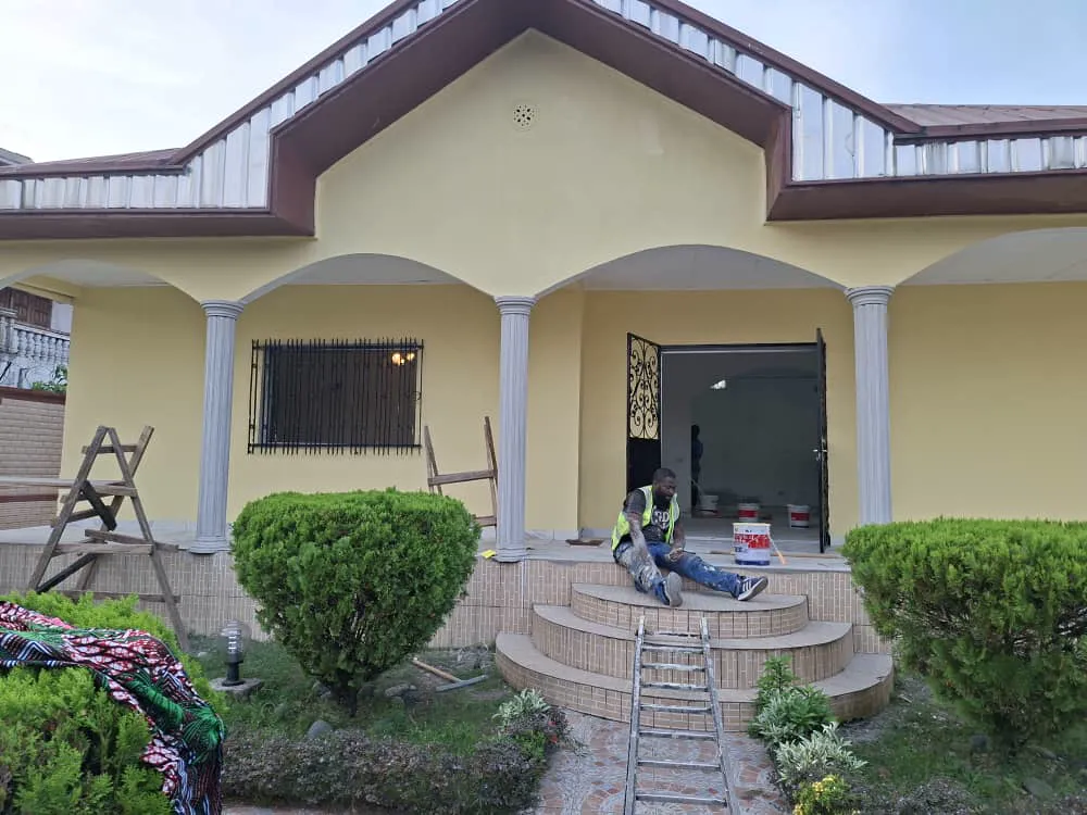 Villa en cours de rénovation, façade peinte et équipe sur le perron