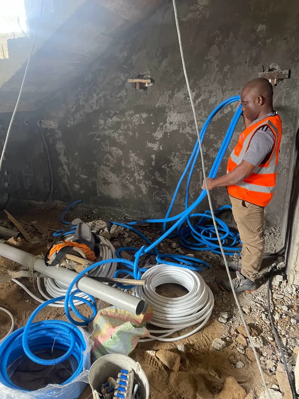 Technicien ETS’2i préparant les réseaux de plomberie sur un chantier à Yassa
